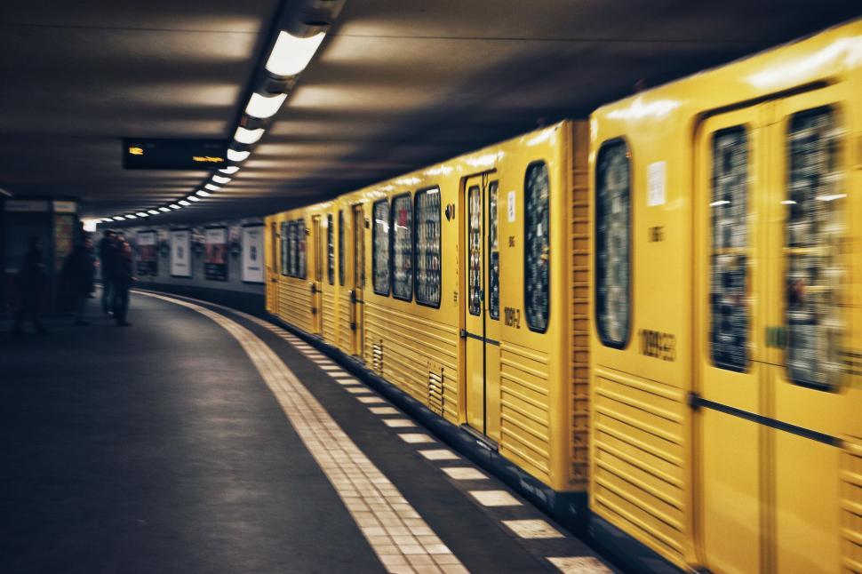 Free Image of Yellow Train Traveling Along Loading Platform 