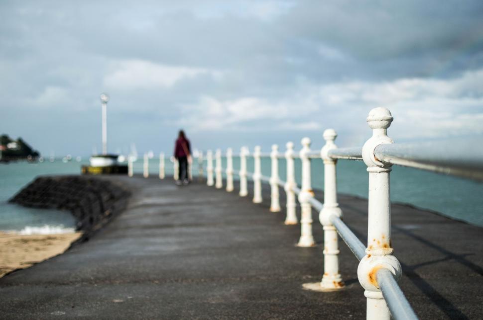 Free Image of Man Standing on Pier by Ocean 