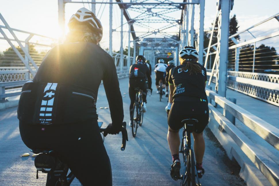 Free Image of Group of People Riding Bikes Across a Bridge 