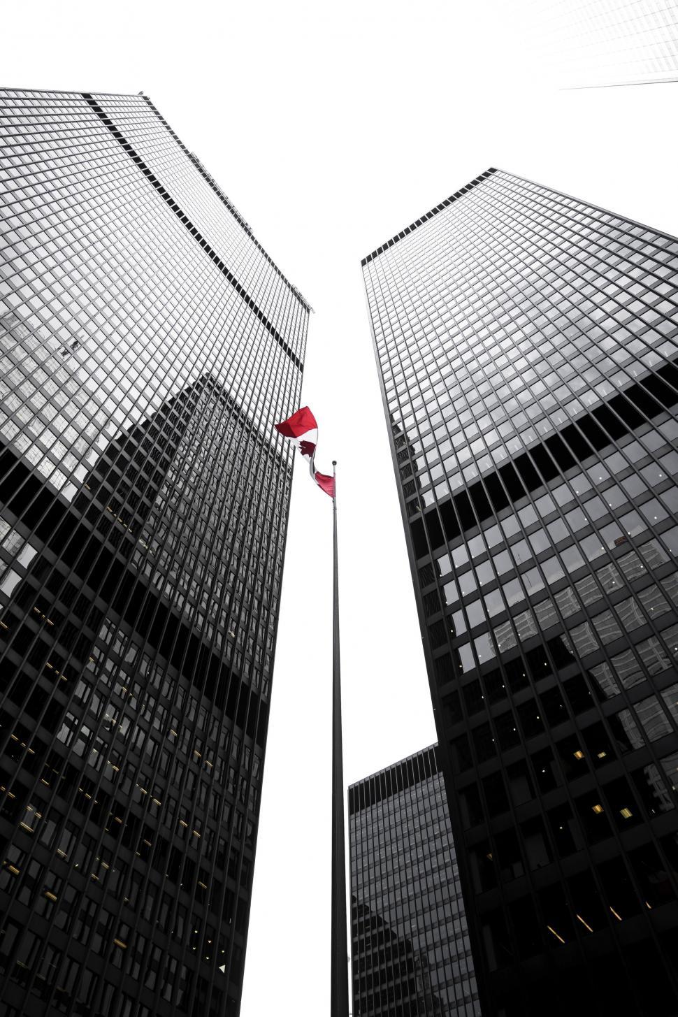 Free Image of Two Tall Buildings With Flag in the Middle 