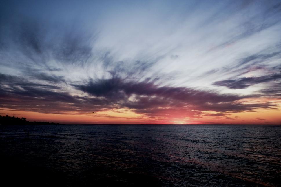 Free Image of Sunset Over Body of Water With Clouds in the Sky 