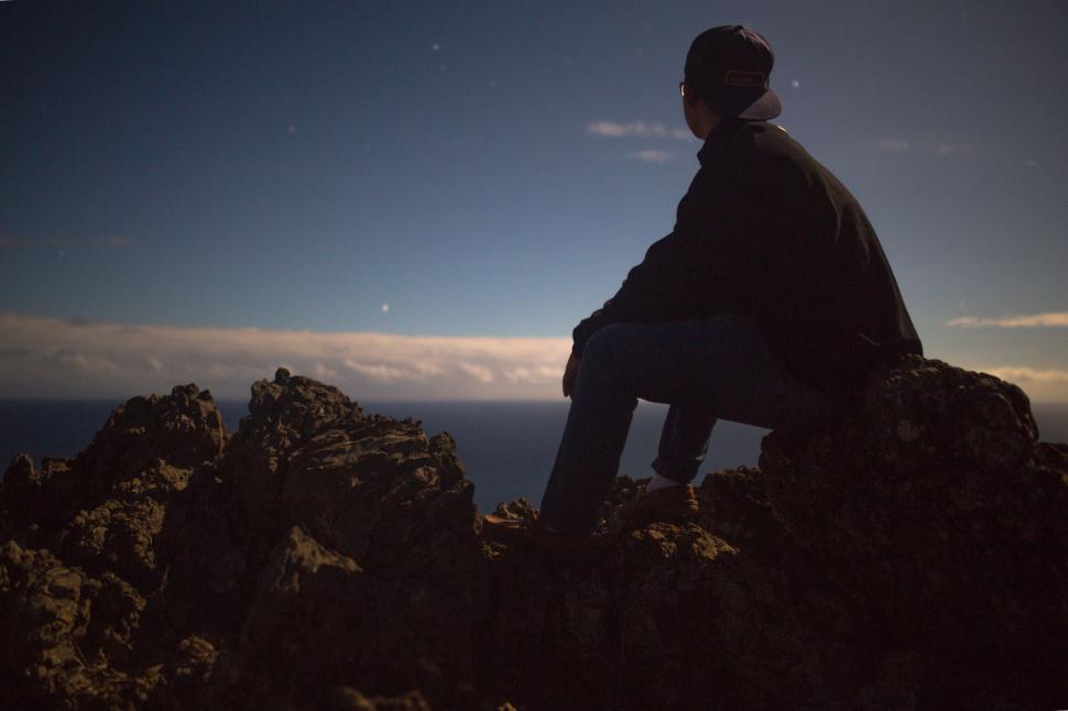 Free Image of Man Sitting on Top of Rocky Mountain 