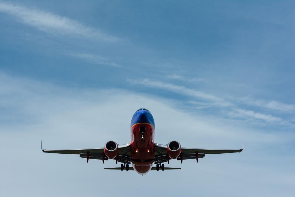 Free Image of Large Jetliner Flying Through a Blue Cloudy Sky 