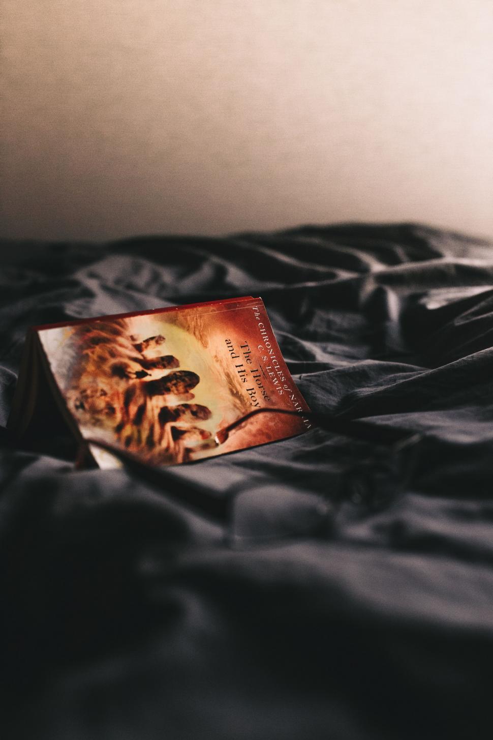 Free Image of Book Resting on Black Bed 