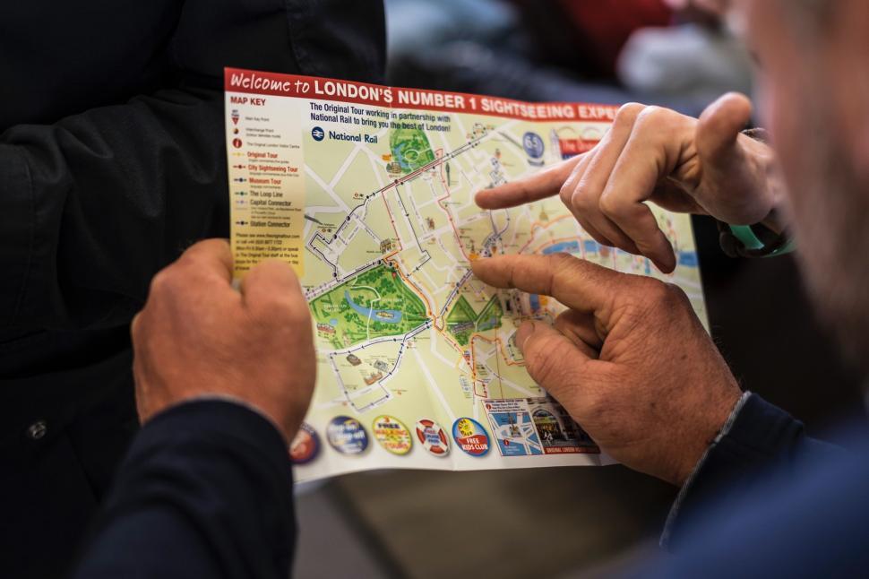 Free Image of Two Men Pointing at a Map 