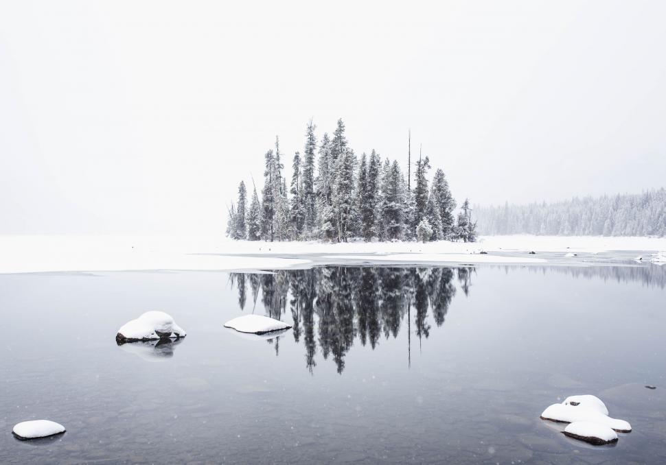 Free Image of Snow Covered Lake Surrounded by Trees and Rocks 