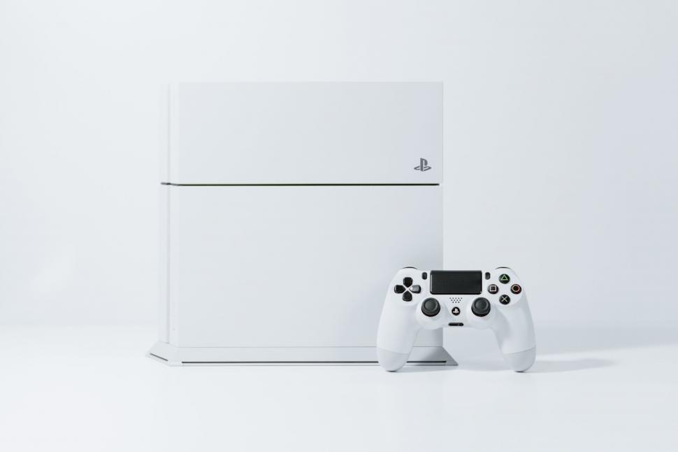 Free Image of Video Game Controllers and White Box Sitting Together 