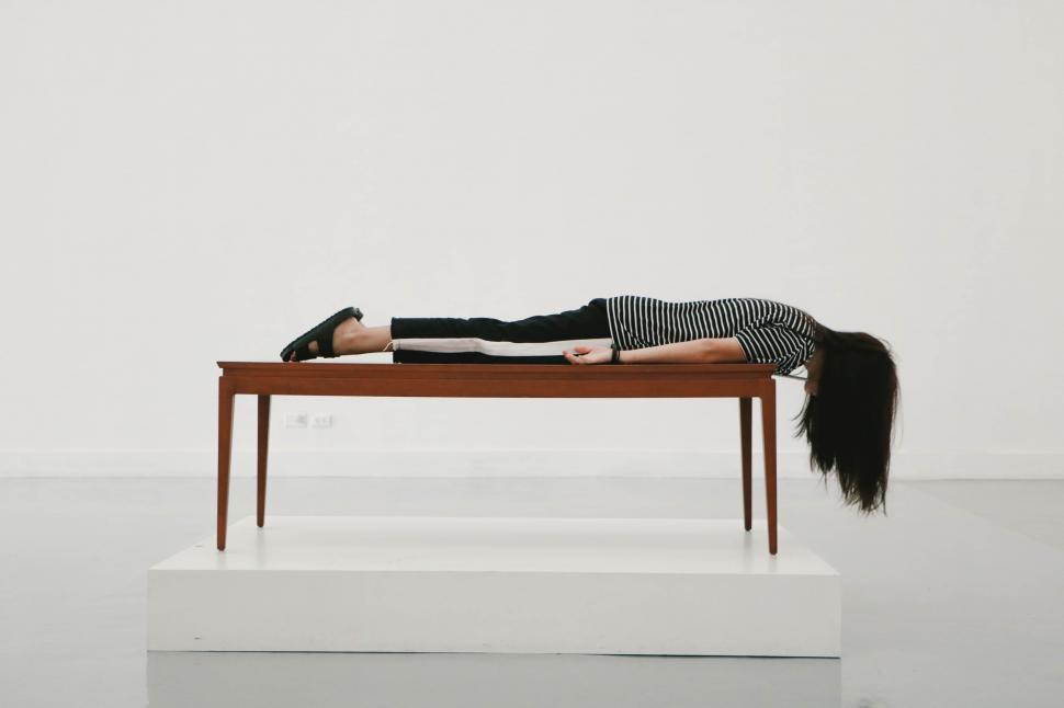 Free Image of Woman Laying on Wooden Table 