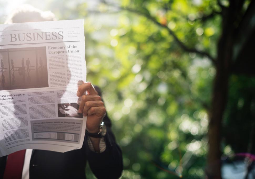 Free Image of Person Holding Newspaper Up to Face 