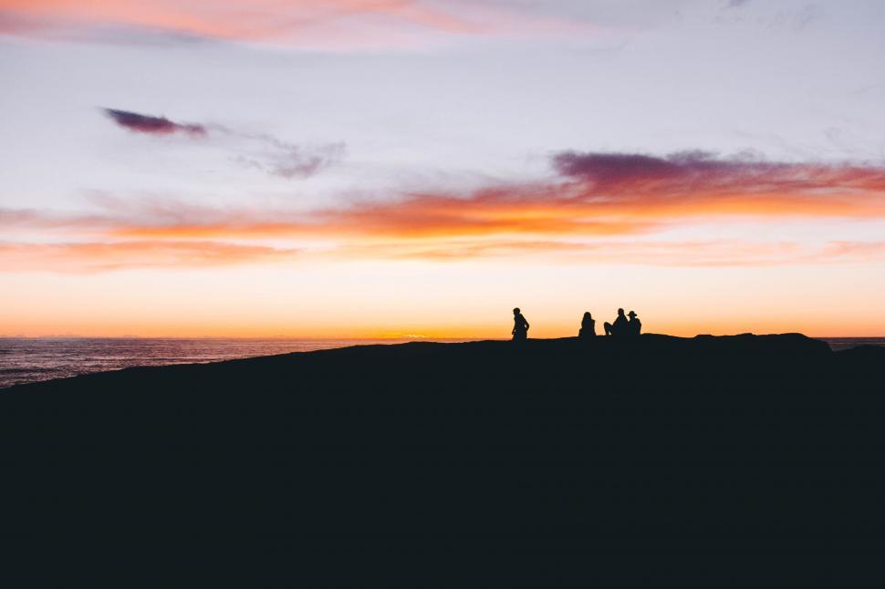 Free Image of Group of People Standing on Top of Hill Near Ocean 