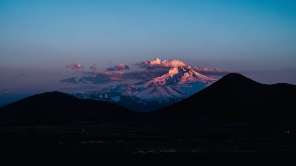 Free Image of Majestic Mountain Range Silhouetted Against the Sunset Sky 