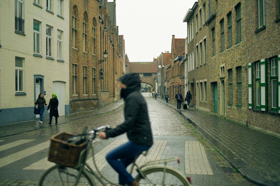 Free Image of Man Riding Bike Down City Street 