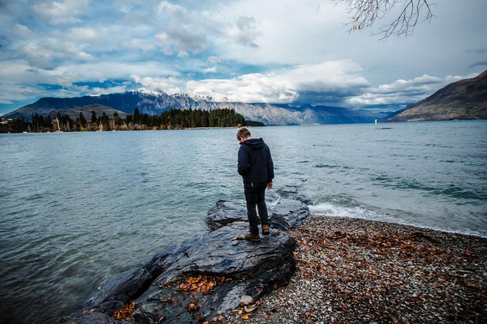 Free Image of Person Standing on Rock Near Water 