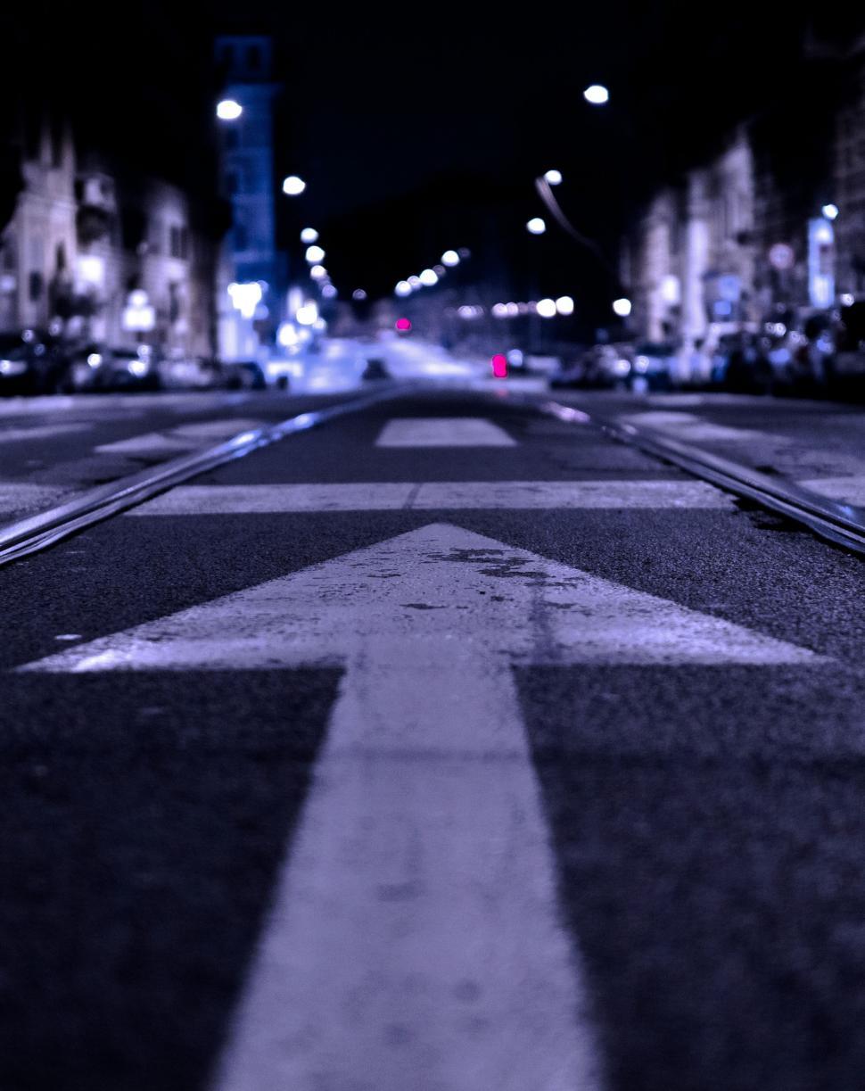 Free Image of City Street at Night With White Arrow 