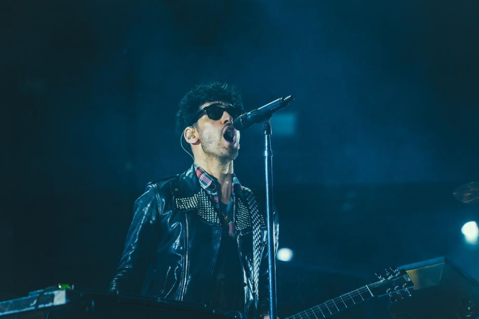 Free Image of Man in Leather Jacket Singing Into Microphone 