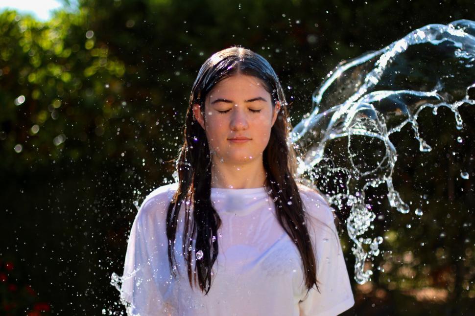 Free Image of Woman Standing in Front of Water Fountain 