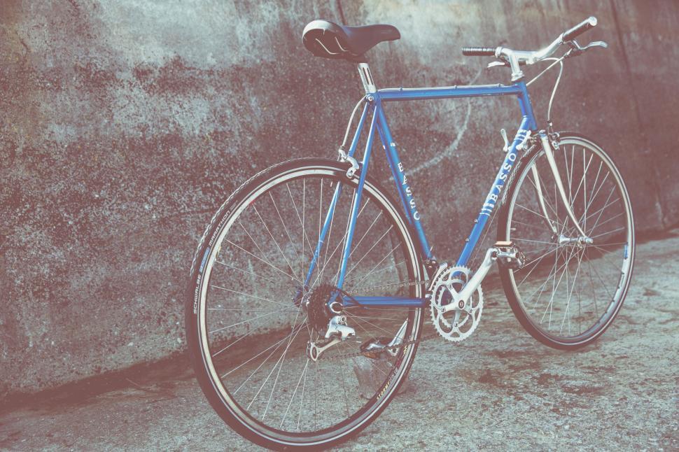 Free Image of Blue Bike Leaning Against Concrete Wall 