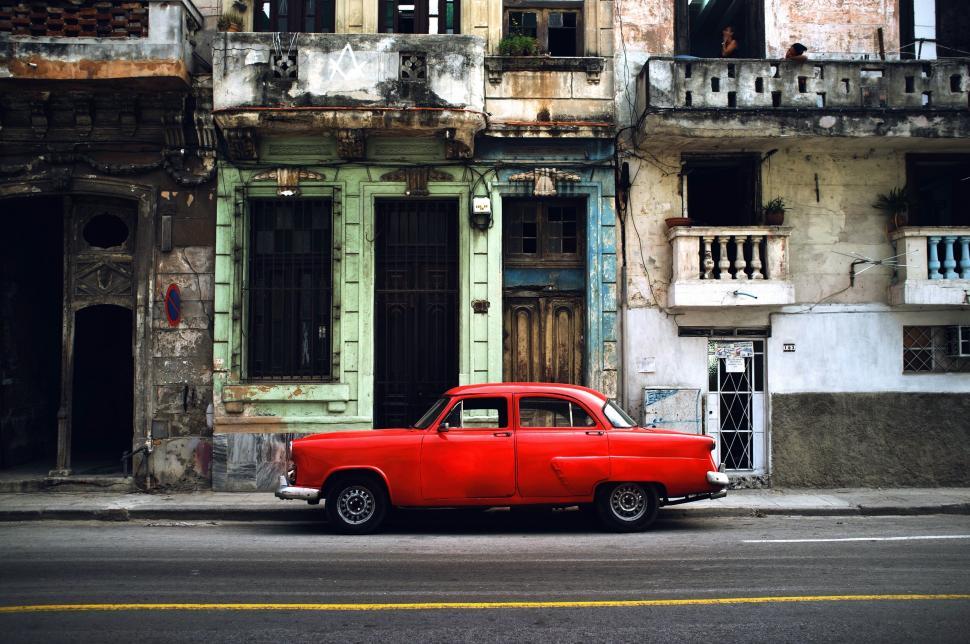 Free Image of Red Car Parked in Front of Building 