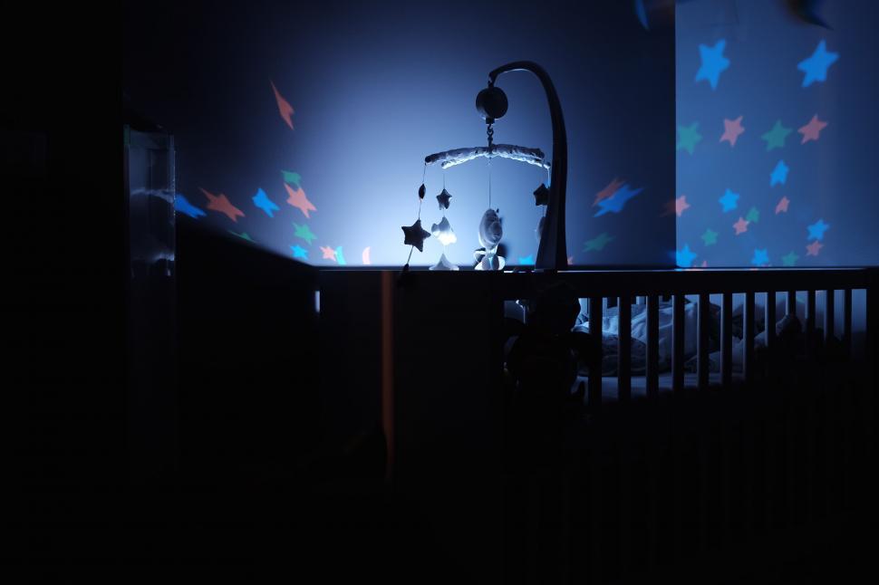 Free Image of Crib in a Dark Room With Stars on the Wall 