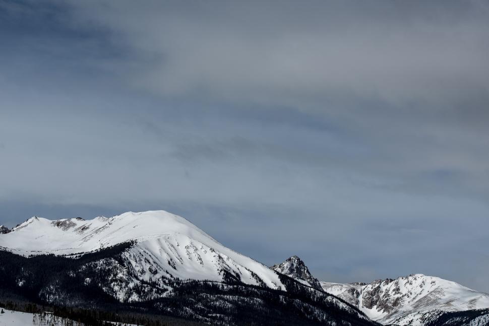 Free Image of Snow-Covered Mountain Range Under Cloudy Sky 