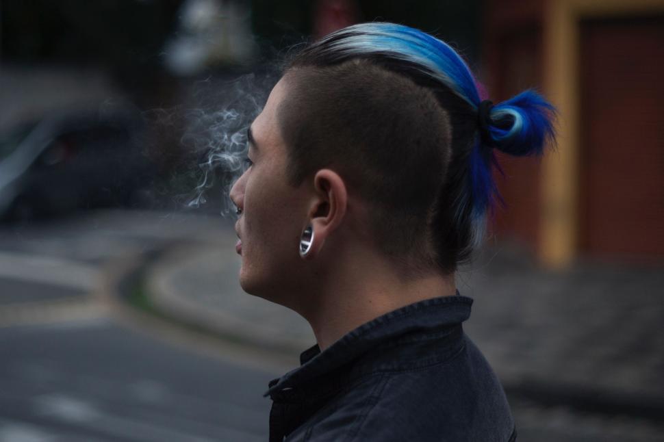 Free Image of Woman With Blue Hair Smoking a Cigarette 