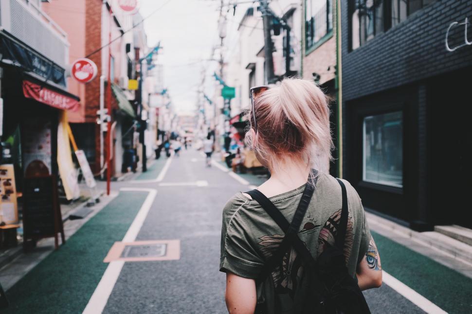 Free Image of Woman Walking Down the Street With a Backpack 