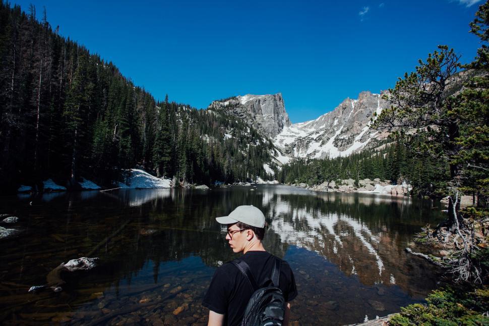 Free Image of Man Standing in Front of Mountain Lake 