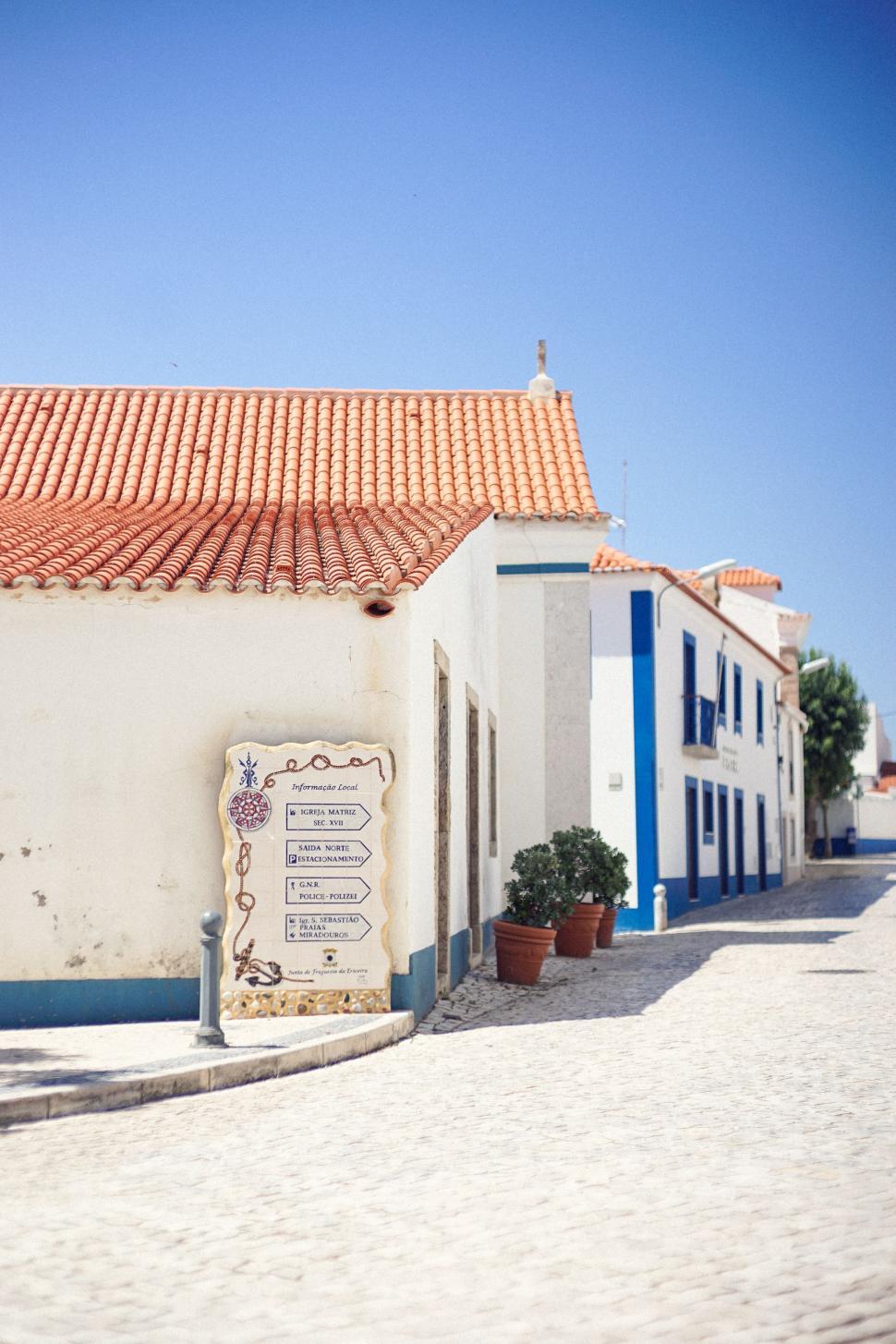 Free Image of White Building With Blue and Red Roof 
