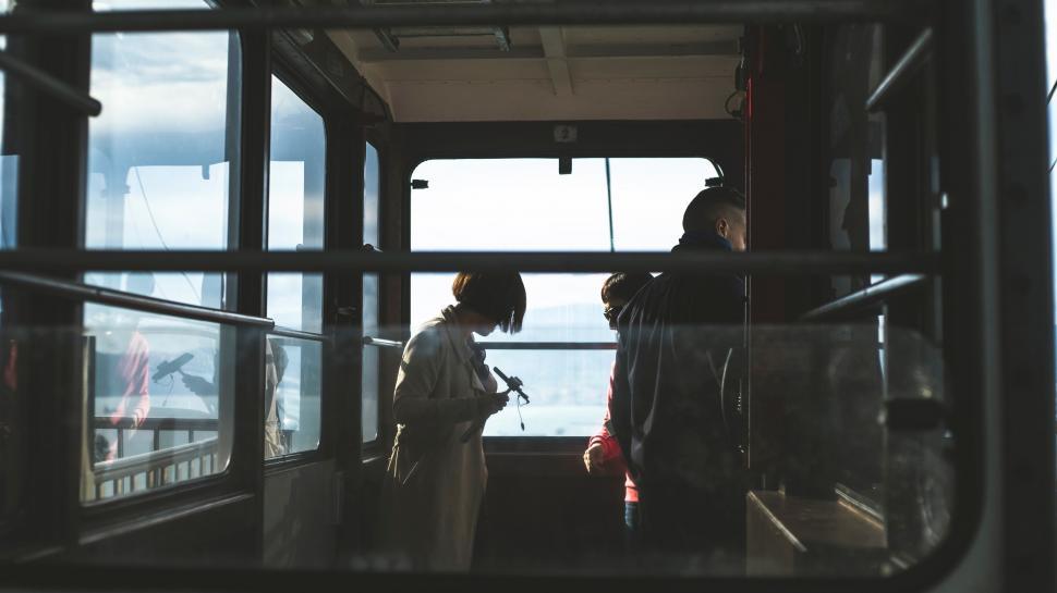 Free Image of Two People Standing on a Bus Looking Out the Window 