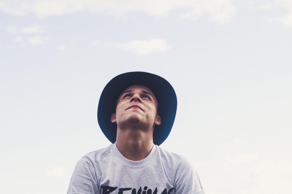 Free Image of Man Wearing Hat Looking Up Into the Sky 