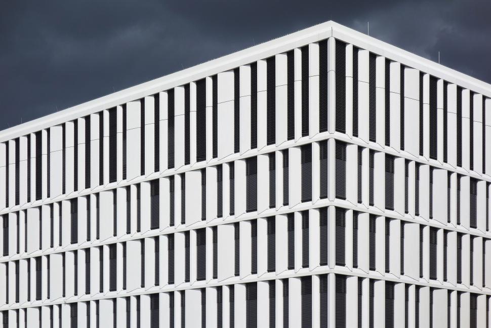 Free Image of Tall White Building Under Cloudy Sky 