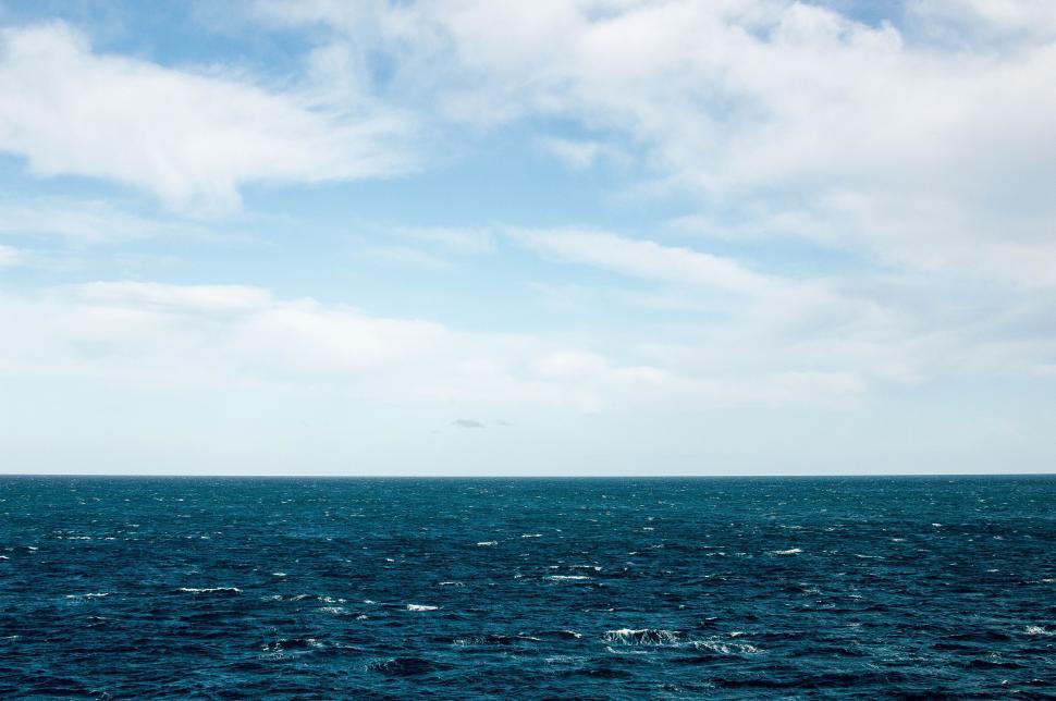 Free Image of Large Body of Water Under Cloudy Blue Sky 