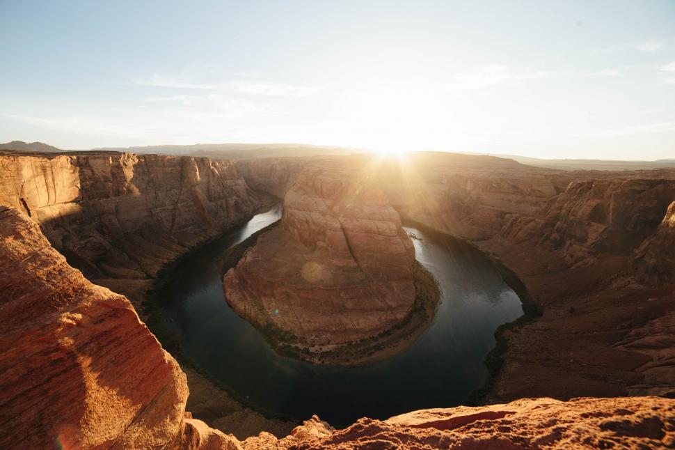 Free Image of The Sun Shines Brightly Over a River in a Canyon 