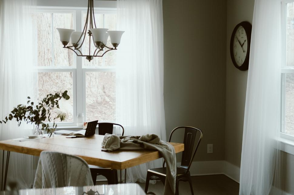 Free Image of Dining Room With Table, Chairs, and Clock on Wall 