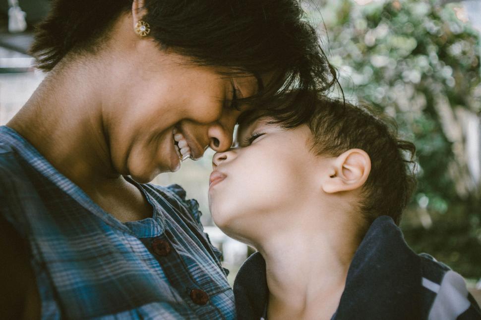 Free Image of Woman Kissing Young Boy With Smile 
