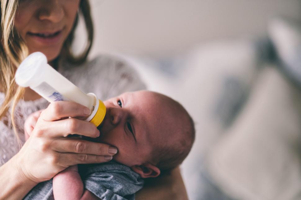 Free Image of Woman Holding Baby With Bottle 