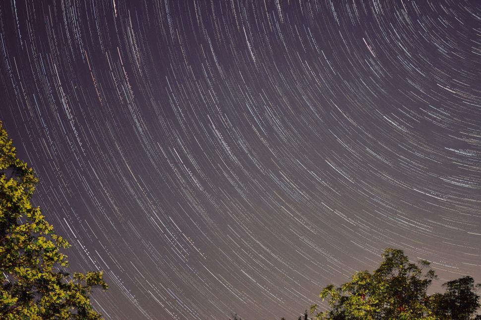 Free Image of Star Trail Over Trees in the Night Sky 