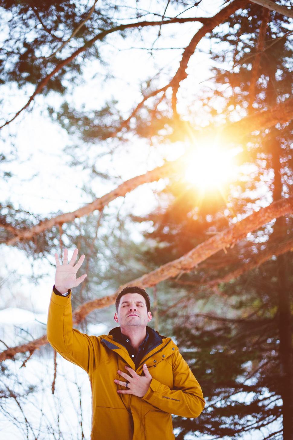 Free Image of Man in Yellow Jacket Standing in Front of Tree 