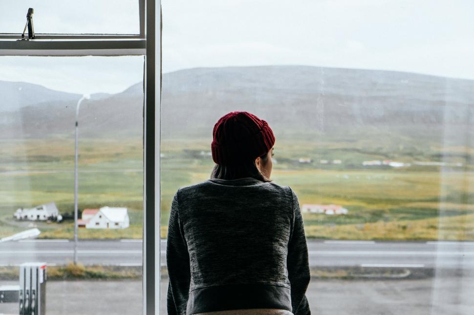 Free Image of Woman Standing in Front of Window at Airport 