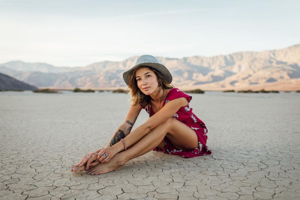 Free Image of Woman in Hat Sitting on Ground 