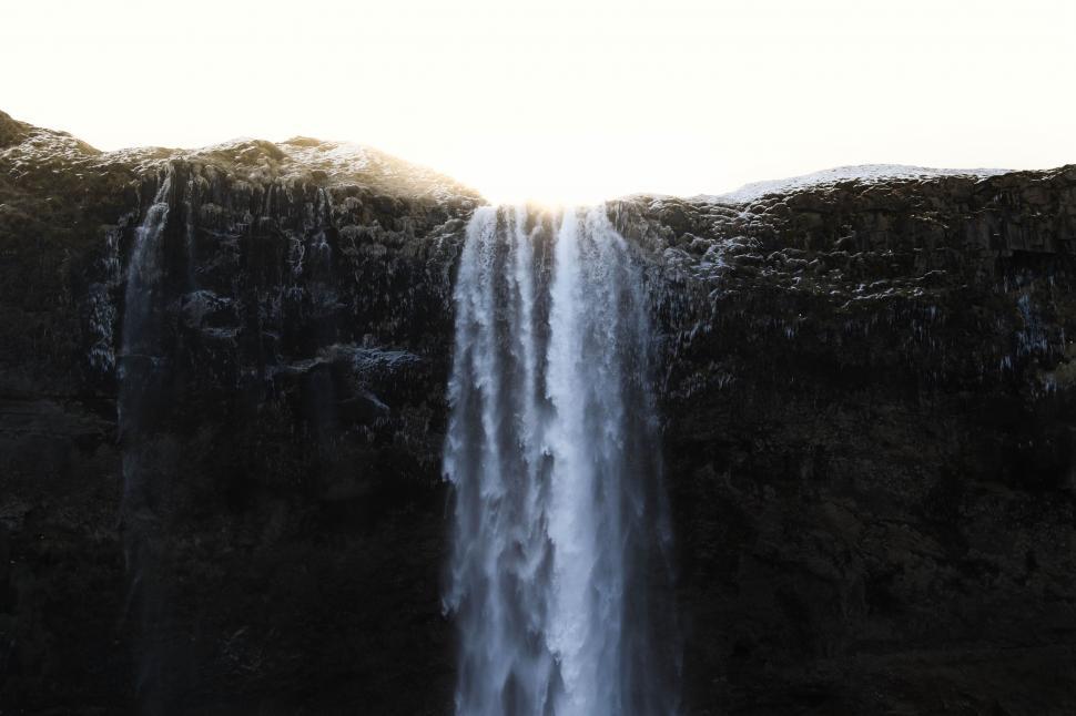 Free Image of Person Standing in Front of Large Waterfall 