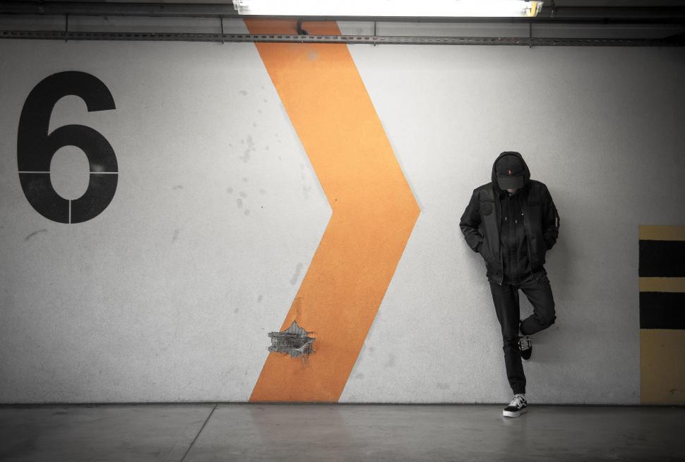 Free Image of Man Leaning Against Wall in Parking Garage 
