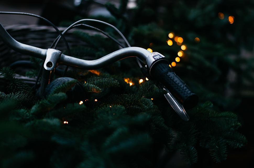 Free Image of Close-Up of Bike Handlebar With Lights in Background 