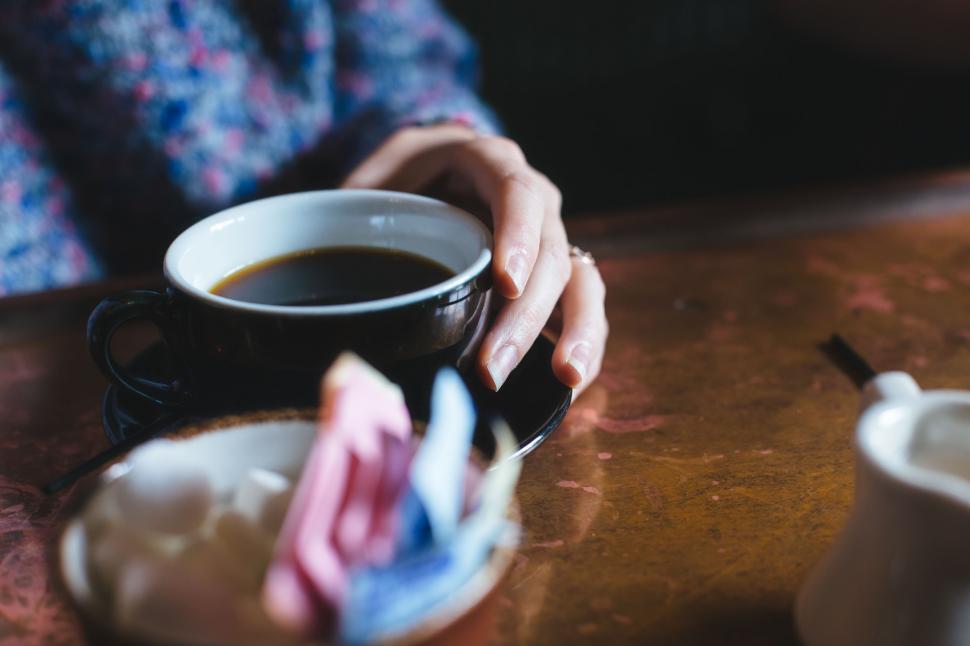 Free Image of Person Holding a Cup of Coffee on a Table 