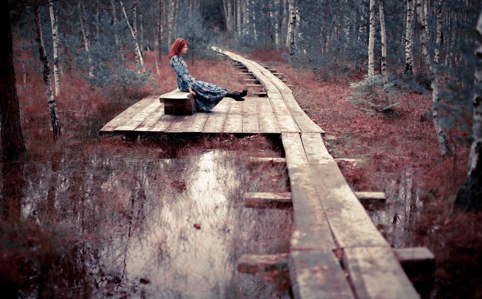 Free Image of Woman Sitting on Dock in Forest 
