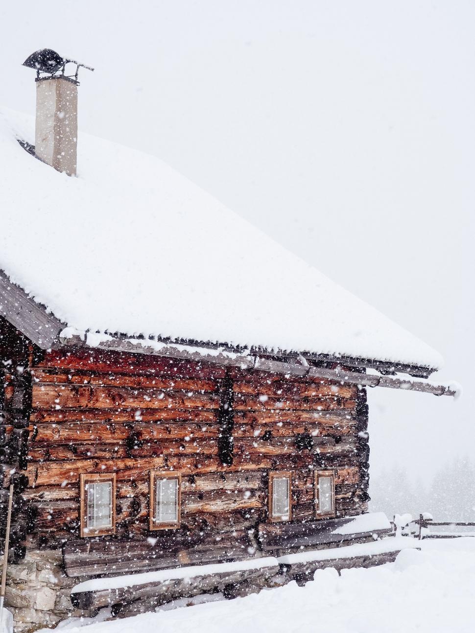 Free Image of Snow-Covered Log Cabin on a Winter Day 
