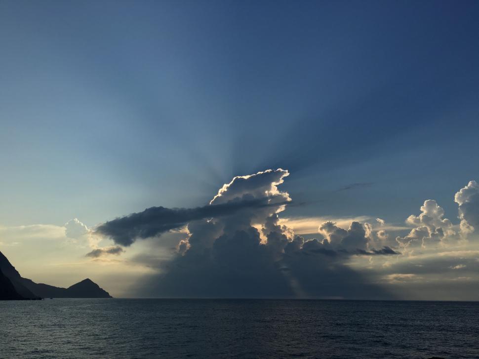 Free Image of Large Cloud Hovering Over Body of Water 