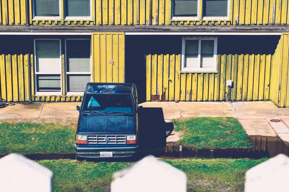 Free Image of Blue Truck Parked in Front of Yellow Building 
