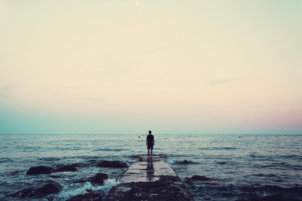 Free Image of Person Standing on Pier Looking Out at Ocean 