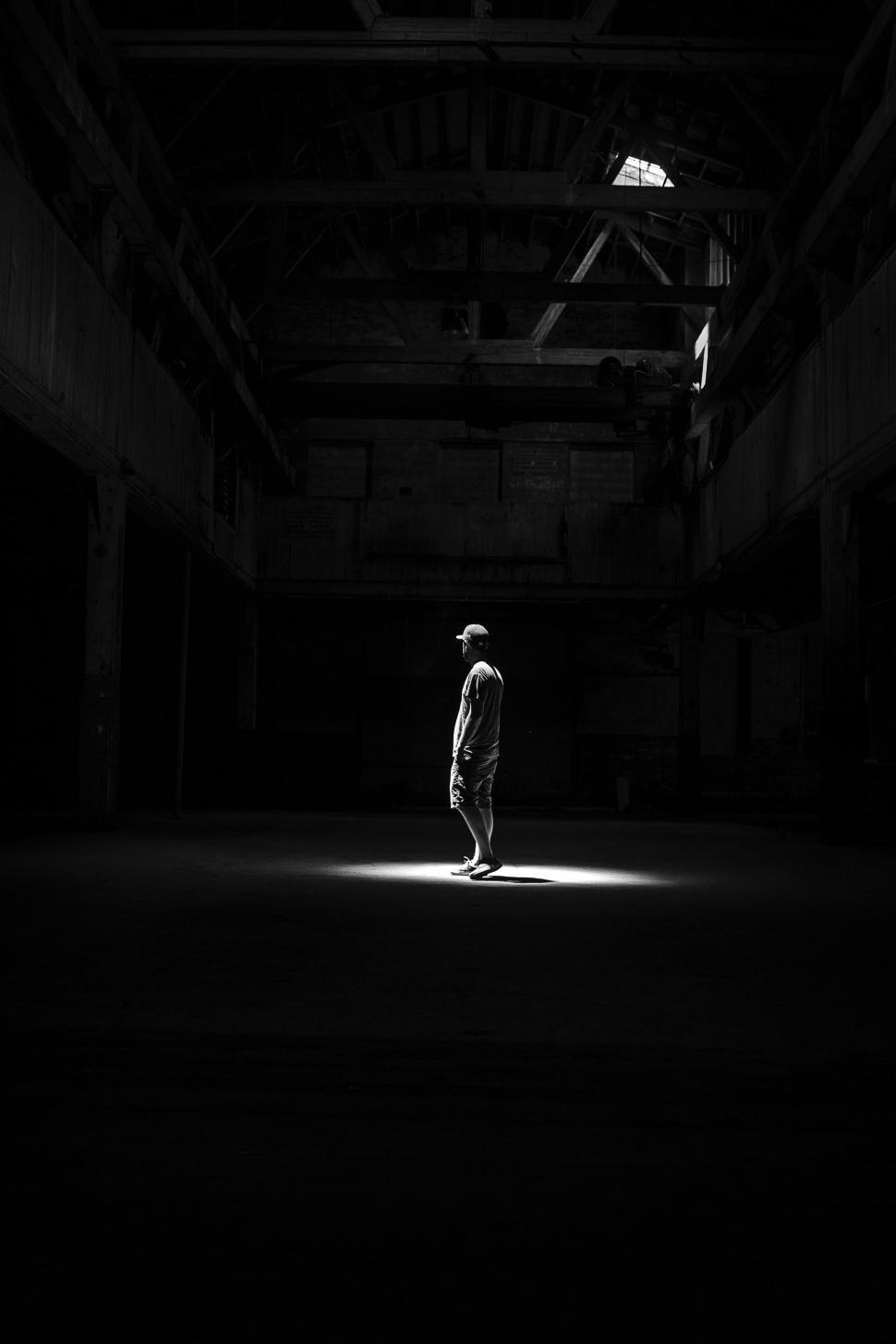 Free Image of Person Standing Alone in Dark Room 